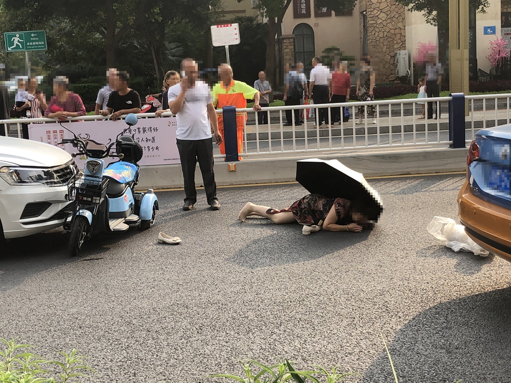 广场附近 一辆电瓶车和一辆小车相撞 电瓶车上的人直接被撞飞摔在地上